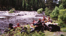 group of atv-ers relaxing on the bank of the river